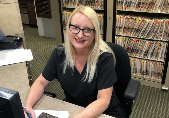 Dental team member behind reception desk