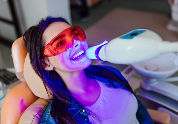 Lady’s teeth are treated with special UV light