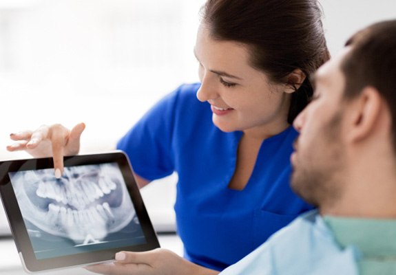 a dental hygienist showing a patient their X-rays