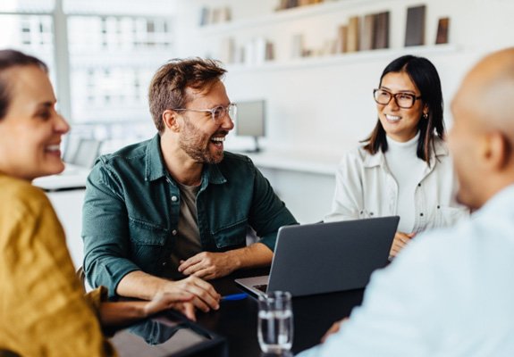 : a team of employees meeting and smiling