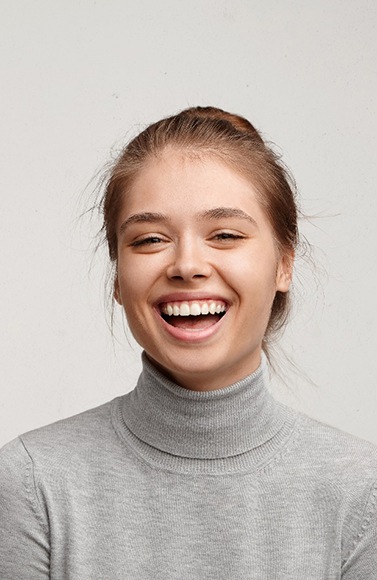 a woman smiling after getting dental crowns in Lewisville