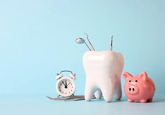 Tooth containing dental instruments next to piggy bank and clock