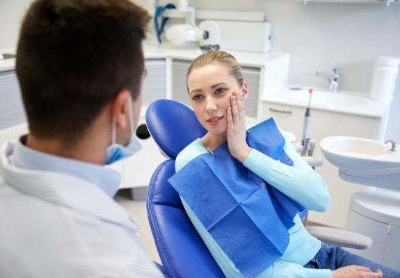 Dentistry patient talking to dentist about how to treat dental emergencies
