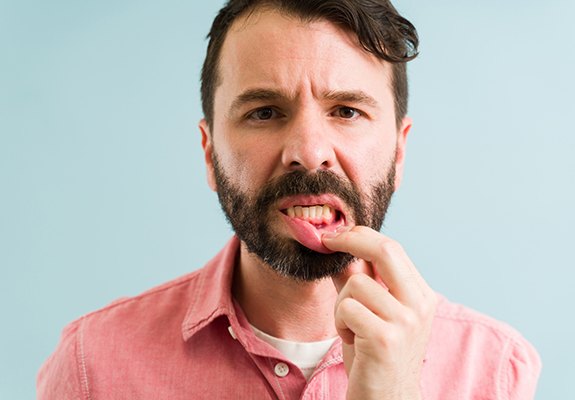 Patient in Lewisville tugging lip to reveal gum disease