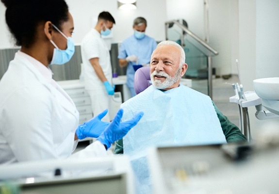 happy man talking to dentist about dental implants in Lewisville