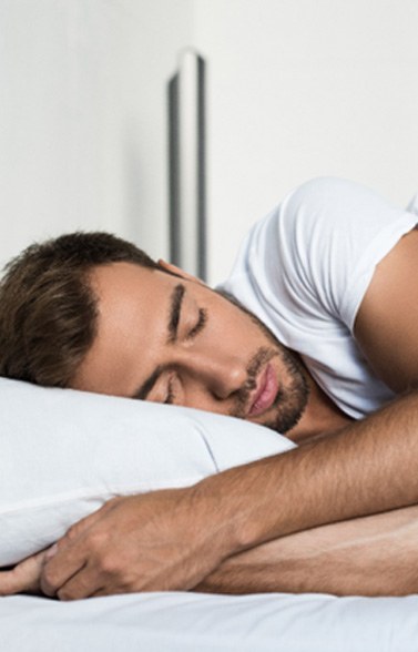 Bearded man sleeping peacefully in his bed