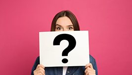 Woman holding a card with a question mark on it