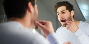 Dentla patient looking at damaged smile before emergency dentistry