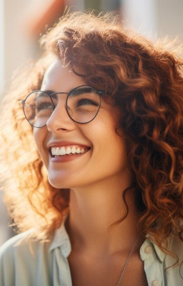 Woman with glasses smiling outside