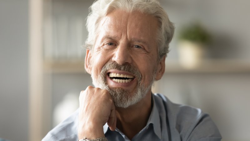 an older man smiling with his dental implants