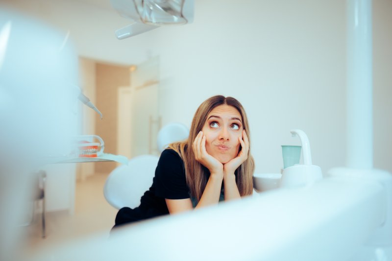 A woman weighing whether to get veneers or dental crowns