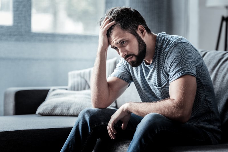 A depressed man sitting down