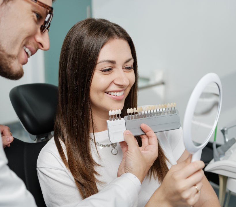 Woman smiling as dentist shows her veneer options